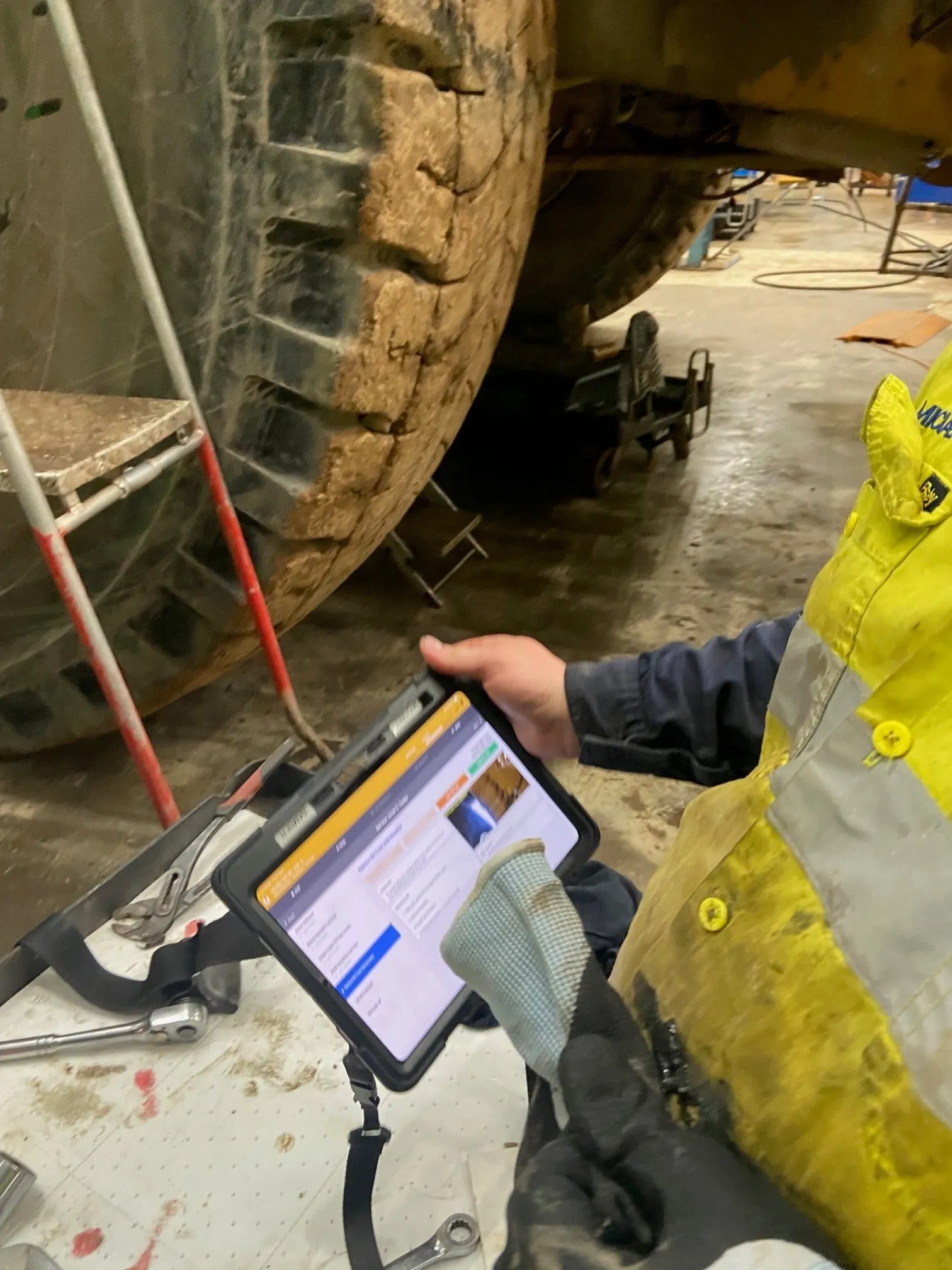 A technician holding the platform on a tablet beside a machine during a service